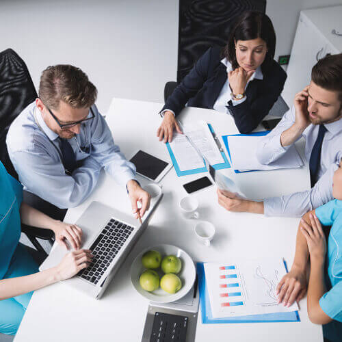 Doctors meeting and working around table.