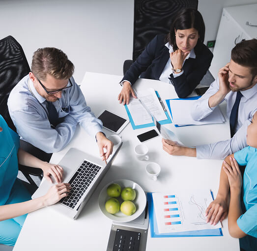 Doctors meeting and working around table.