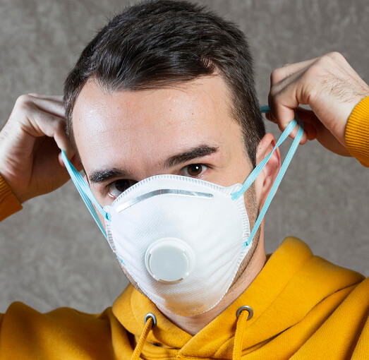 Man putting on respirator.
